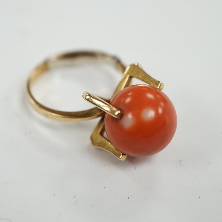 A continental yellow metal and single stone coral bead set dress ring, size O, gross weight 7.7 grams. Condition - fair